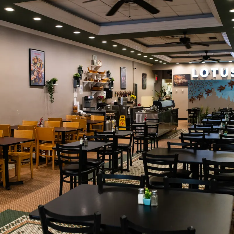Dining room at Lotus Thai and Sushi with the LOTUS sign and Thailand artwork